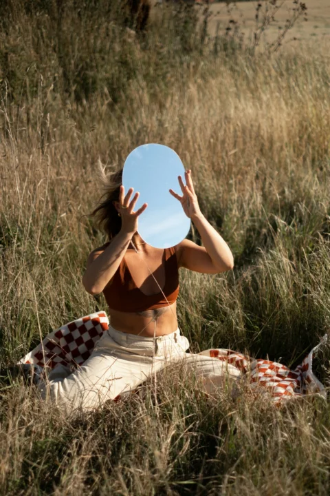 a person is sitting in the grass with a frisbee
