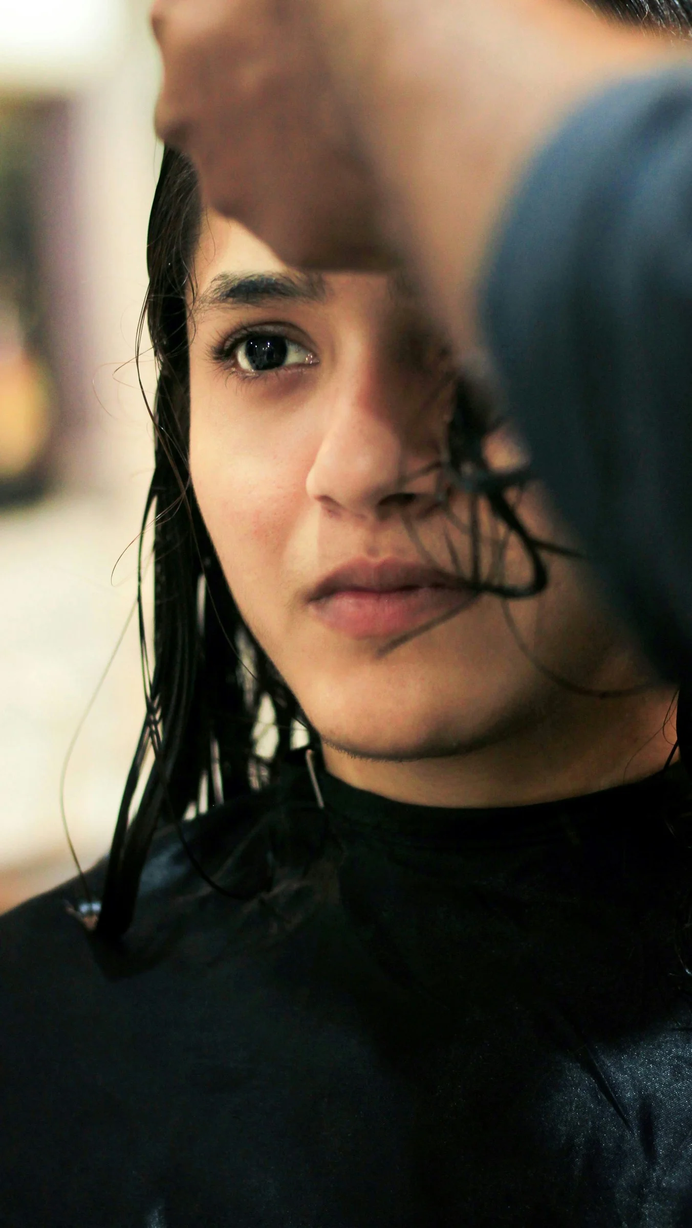 A woman getting her hair done by a hair stylist