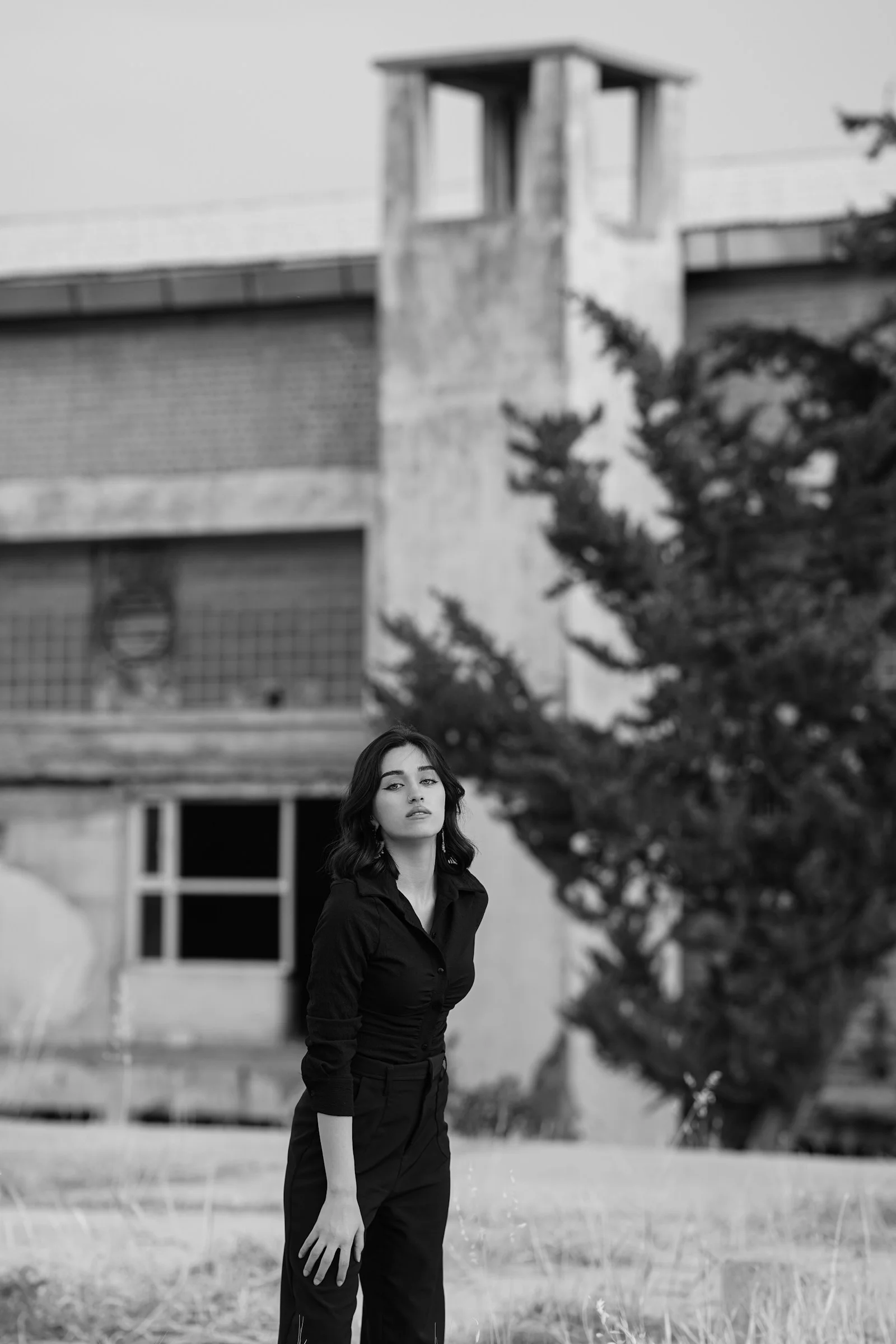 一位女人站在建筑物前的田野里
