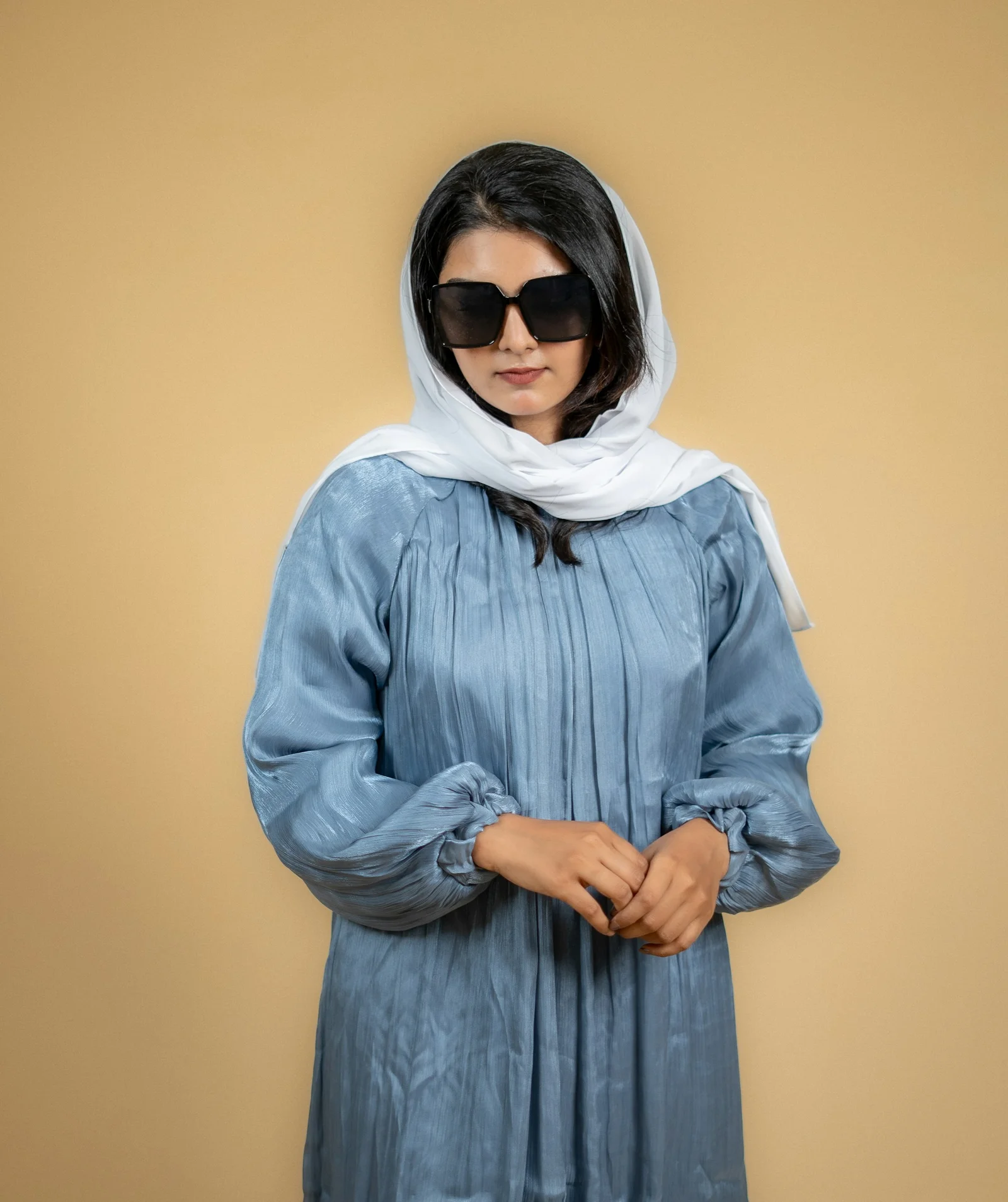 a woman wearing a blue dress and a white scarf