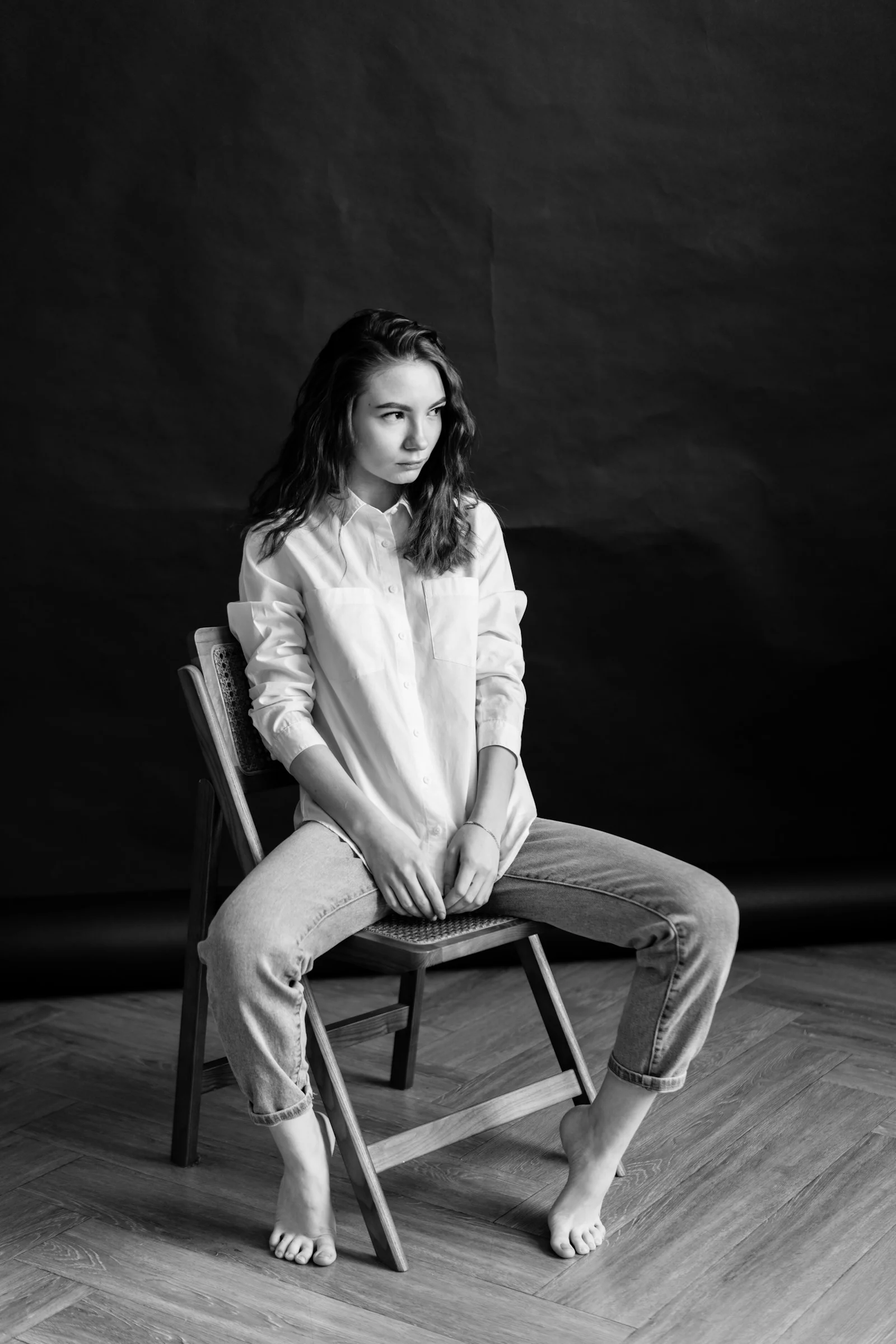 a black and white photo of a woman sitting on a chair