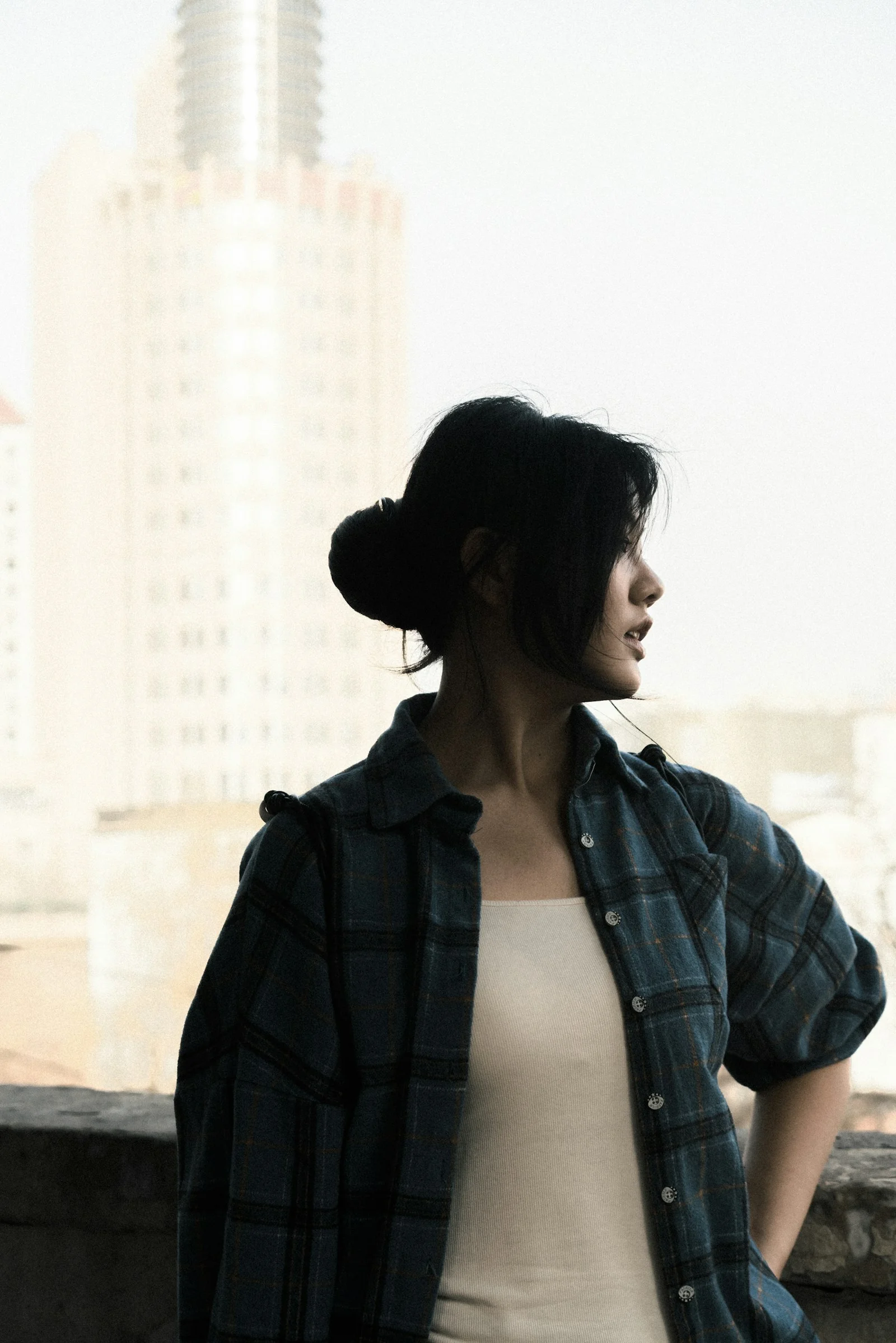 Young woman in plaid shirt looking away from camera