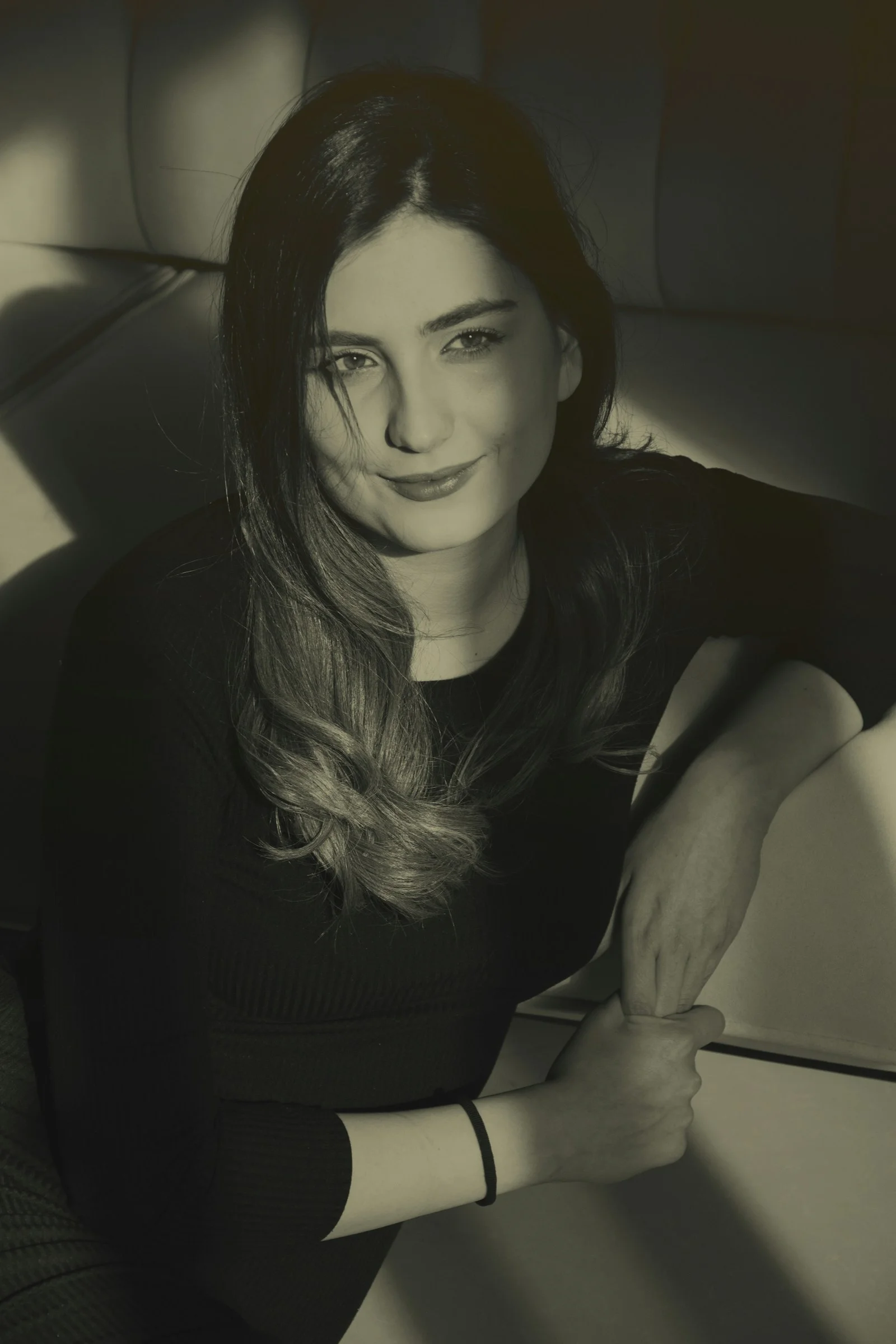 a black and white photo of a woman sitting on a couch