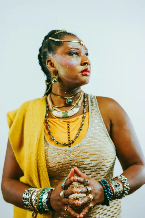 A woman adorned with jewelry and face paint