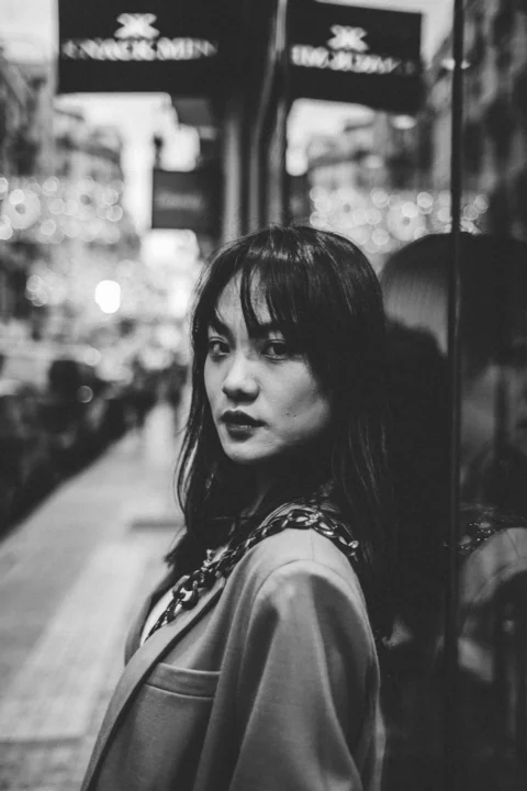 建筑物旁女子的灰度摄影