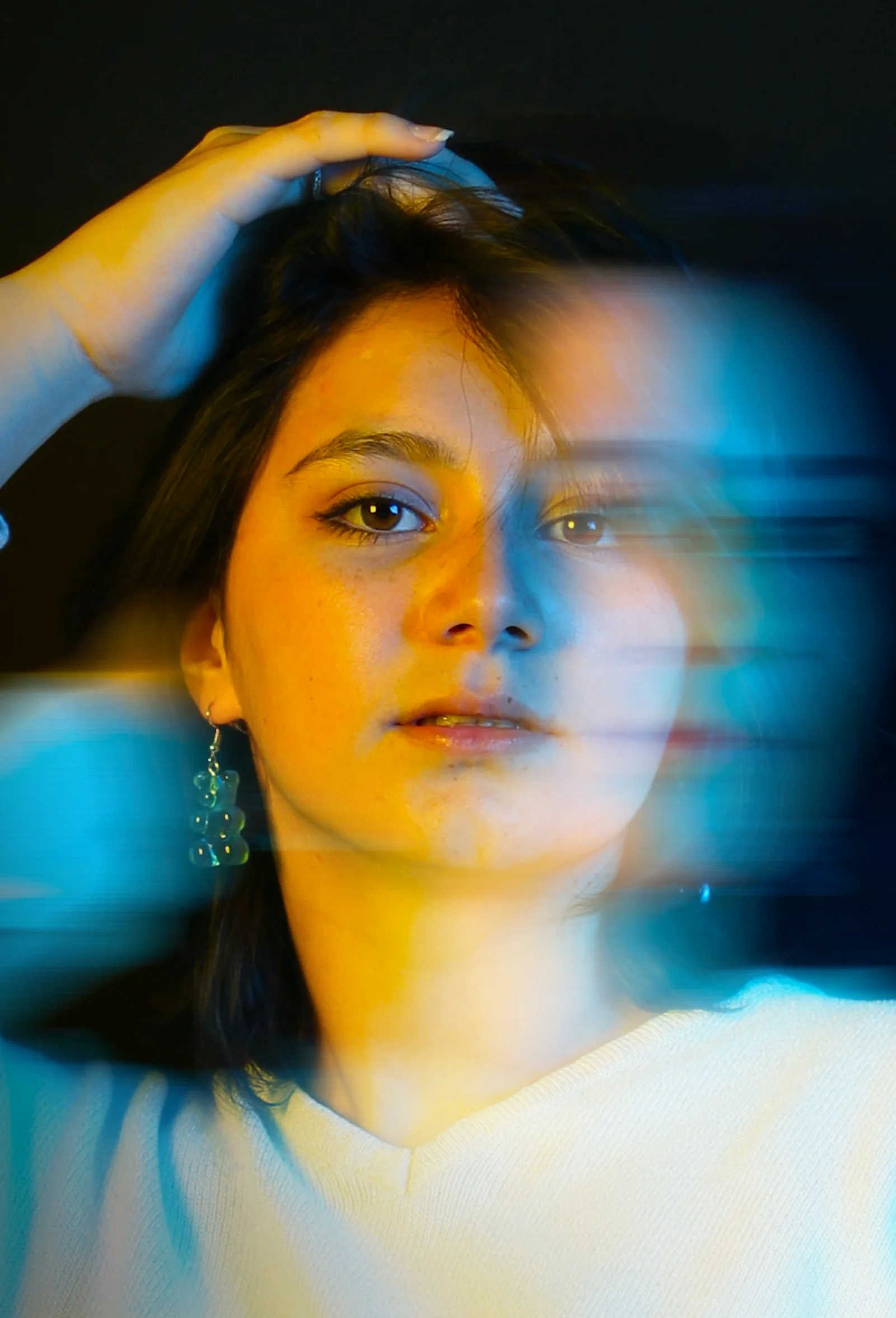 a woman in a white shirt is holding her hair