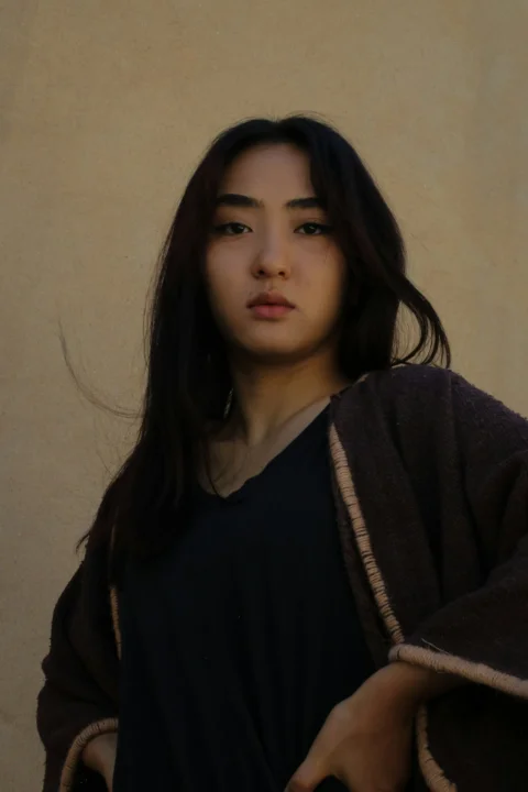 黒いシャツと茶色のローブを着た女性