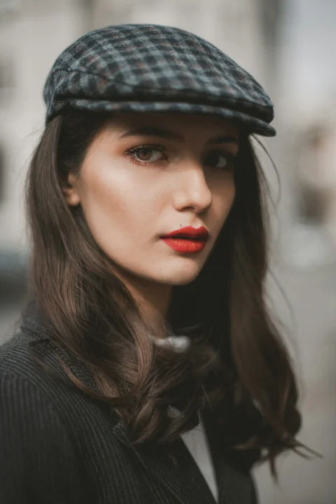 a woman wearing a hat and red lipstick