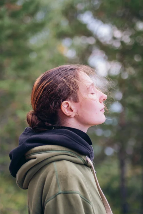 a woman standing in front of a forest