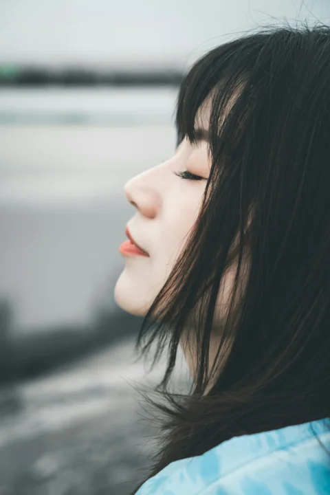 A woman with long black hair and a blue shirt