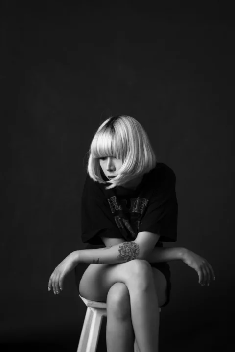 a woman sitting on top of a stool