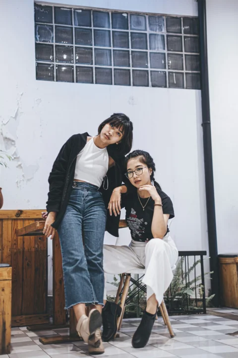 两个女人在一栋建筑物前摆姿势拍照