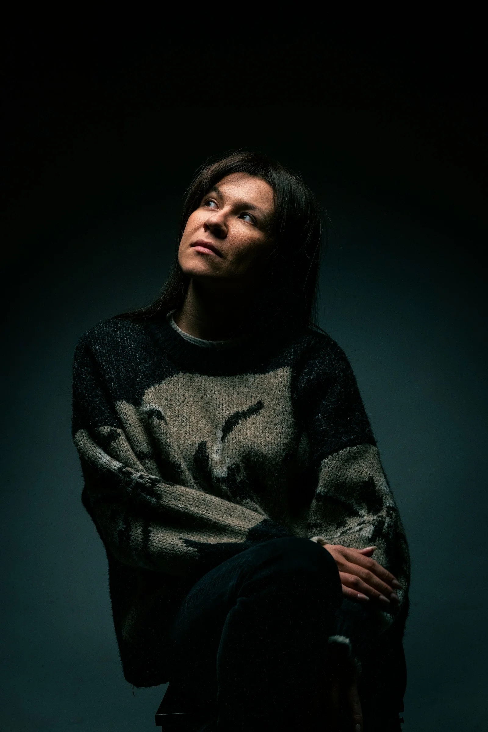 A woman sitting on a chair in a dark room