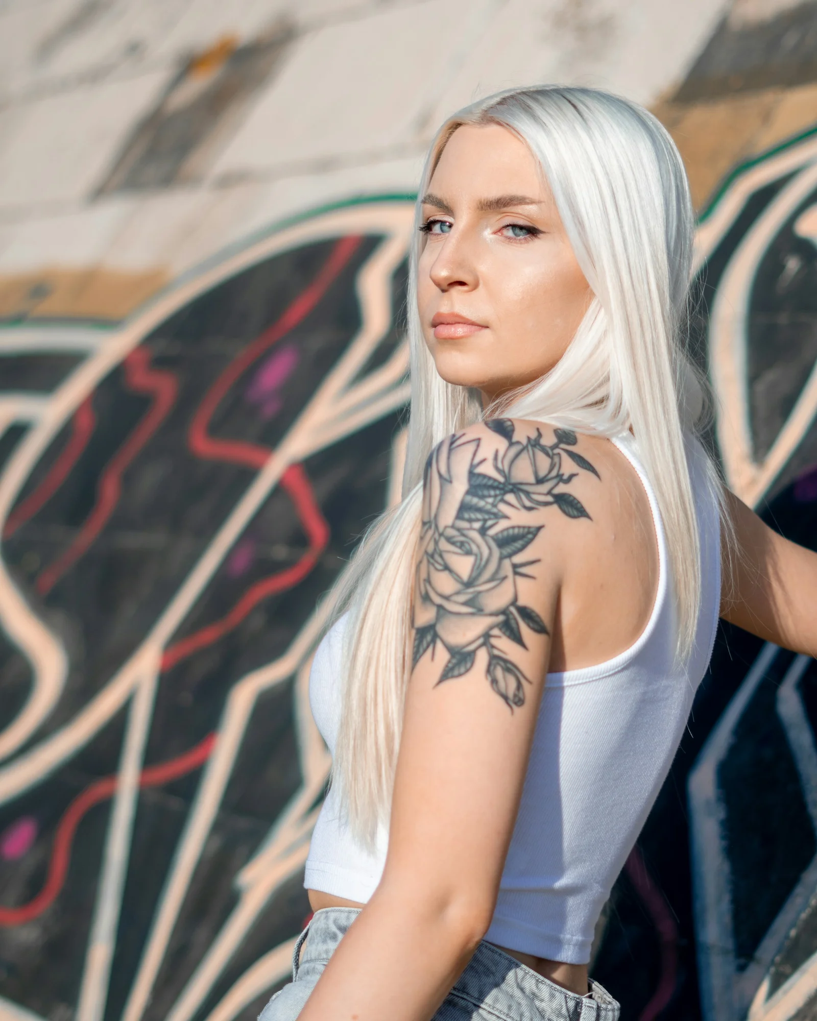 woman in white tank top with black floral tattoo on her back