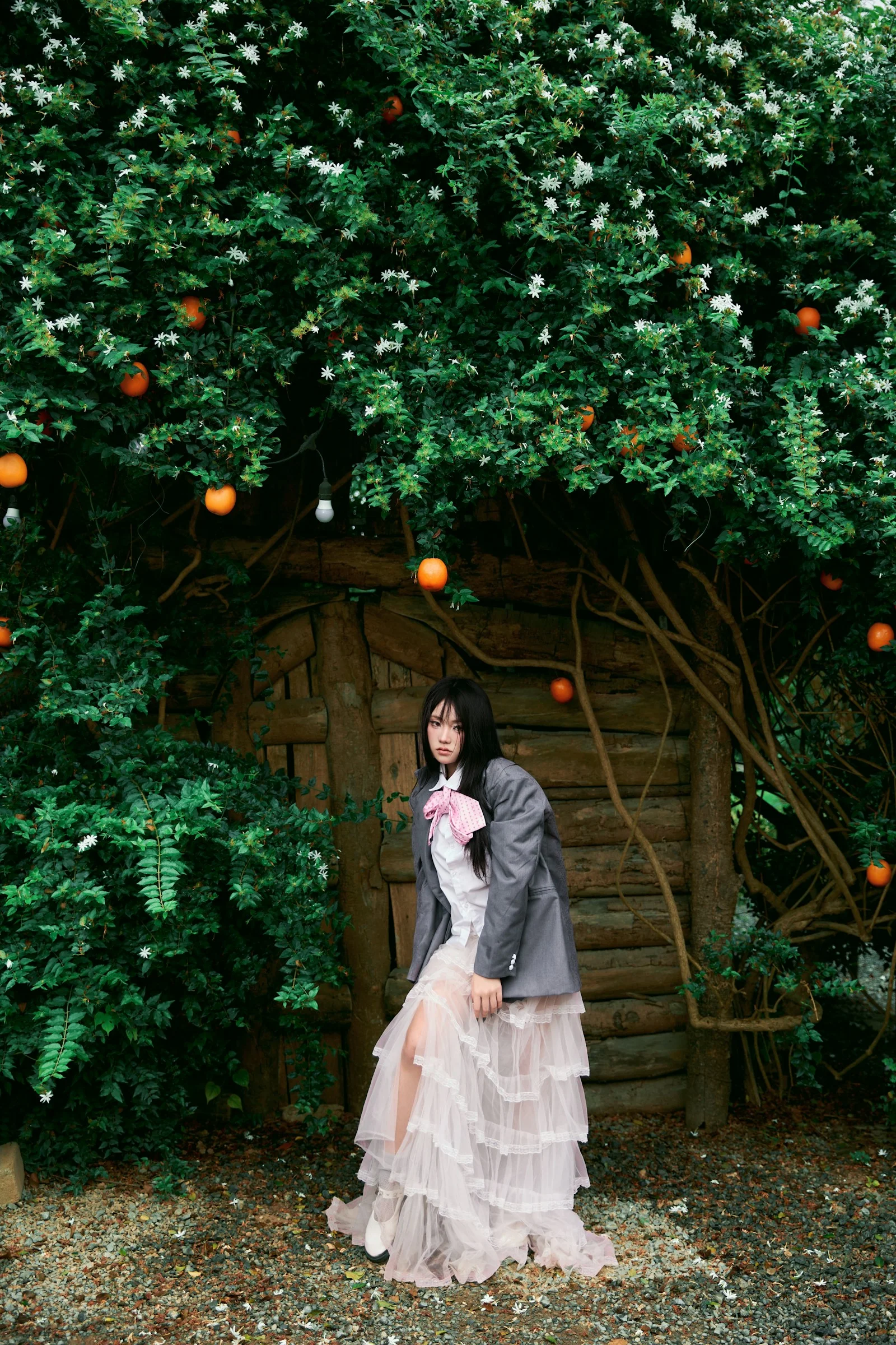 Woman in a long skirt under a tree with oranges