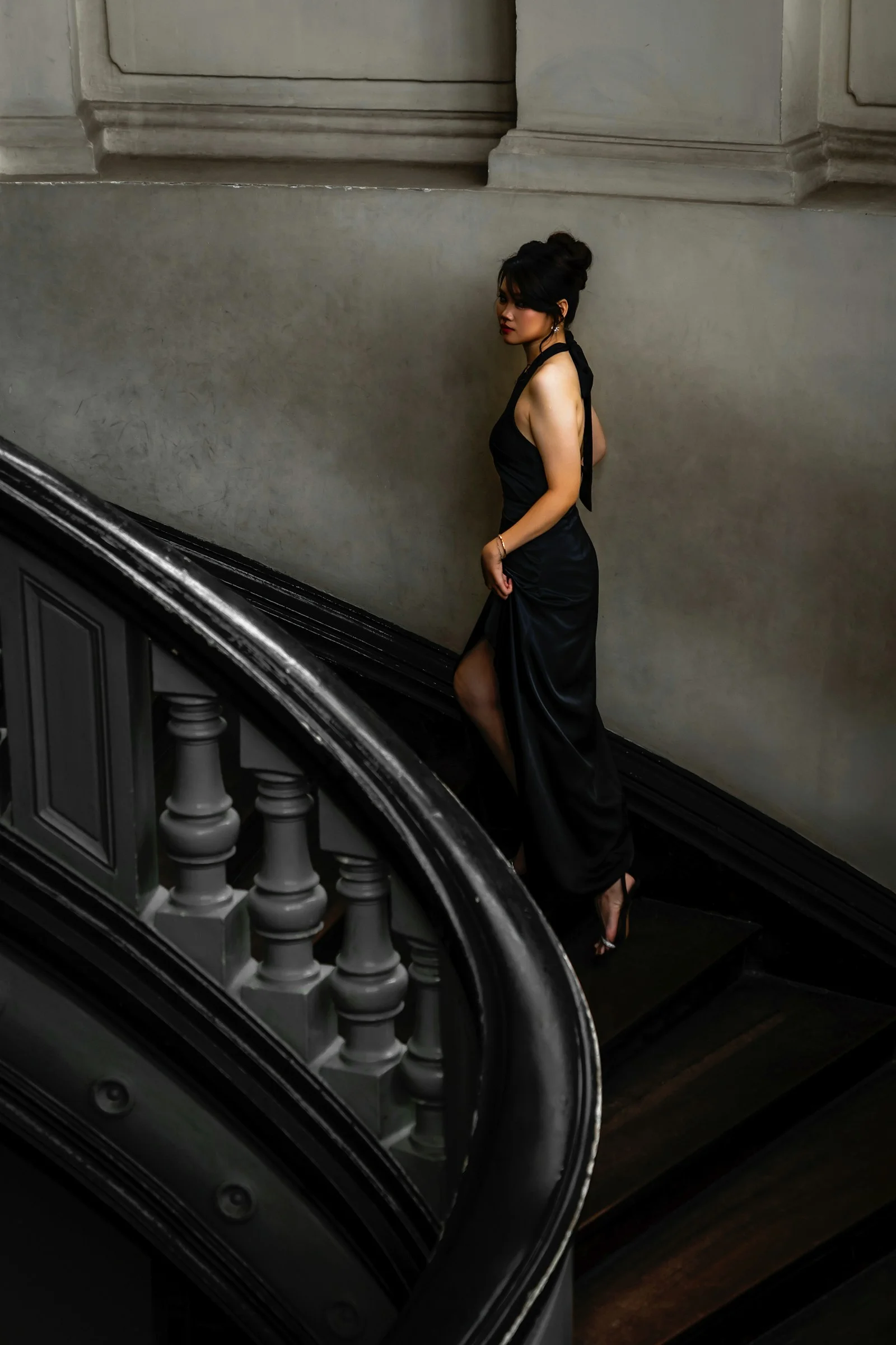 Woman in black dress walking up stairs
