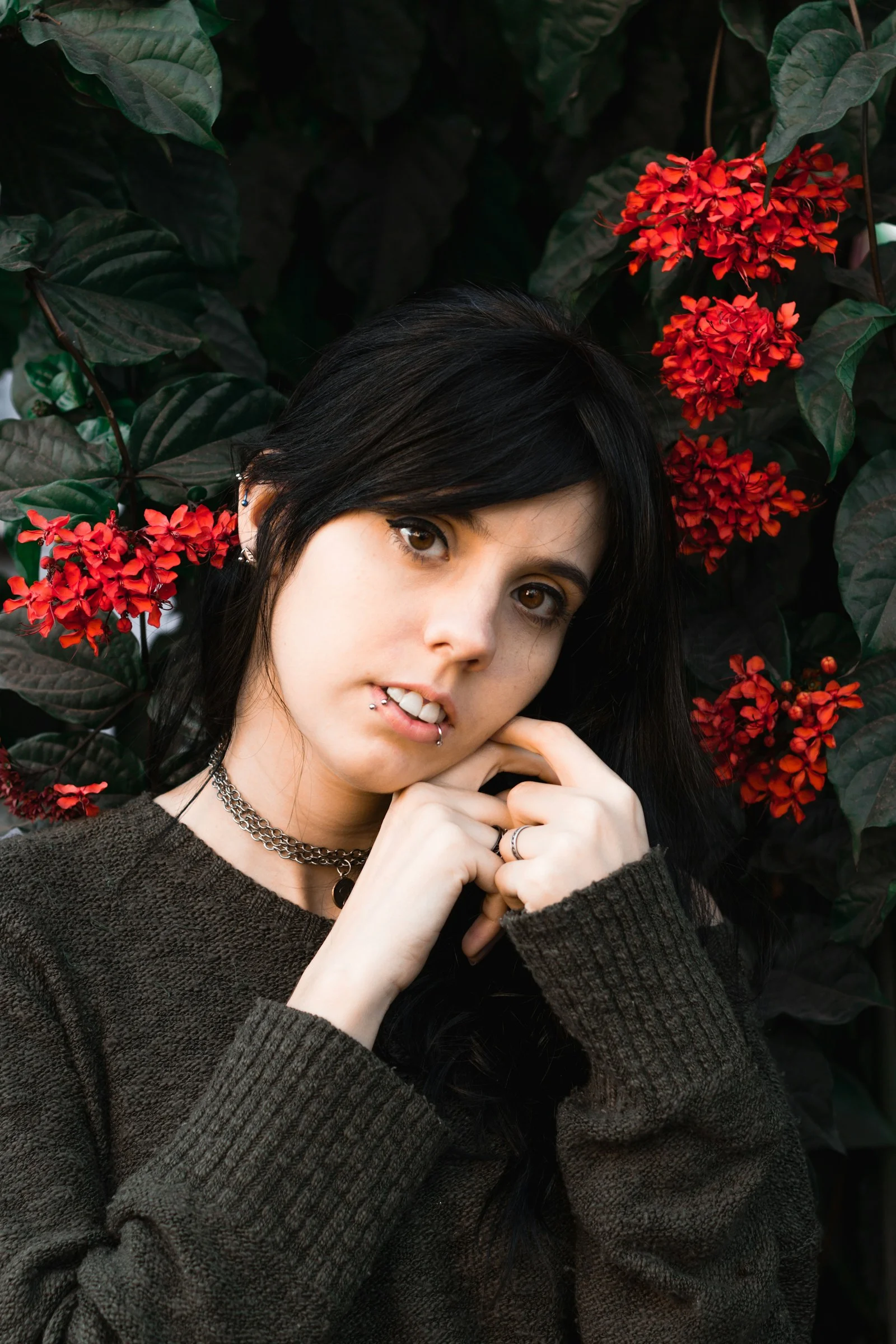 woman standing near red flower plant