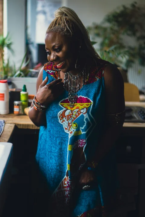woman in blue tank top holding string lights
