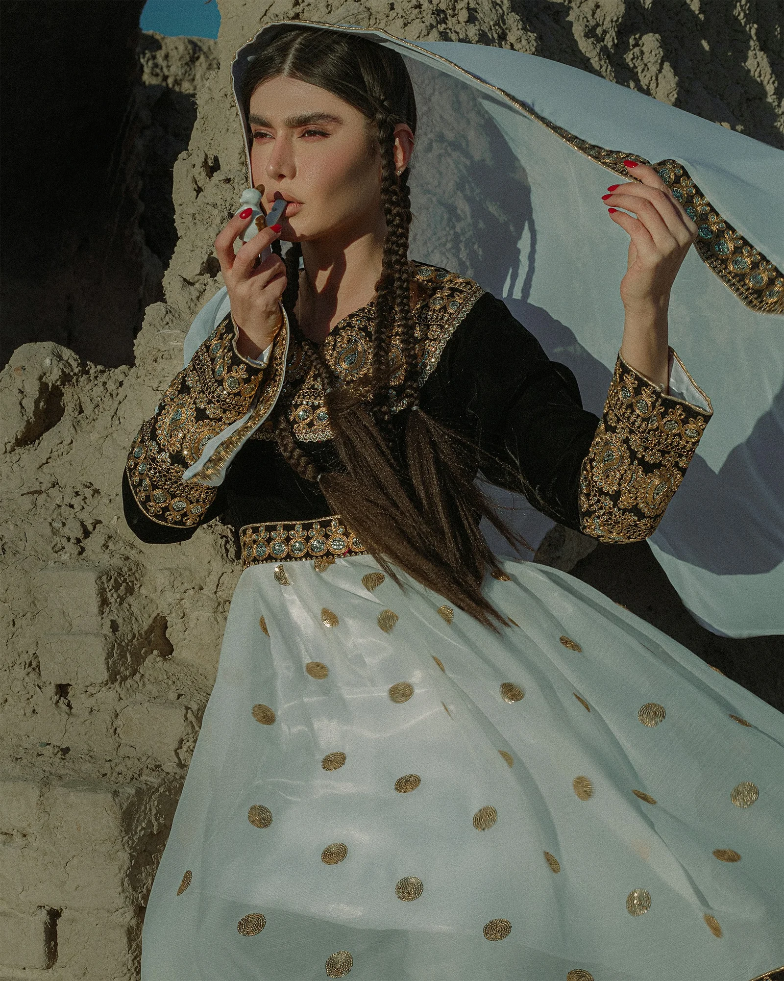 a woman in a long white dress holding an umbrella